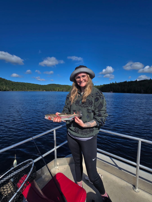 Adolescente près du lac avec un truite pêchée à la pourvoirie Réal Massé